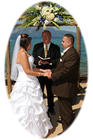 Pastor Orr performing a beach ceremony in front of the arbor