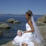 Happy bride sitting on rock