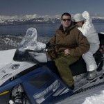 Pausing their snowmobile for a moment for a photo