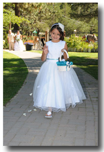 Flower girl throws petals as she walks down the wedding aisle