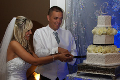 The bride and groom cutting their wedding cake at the reception