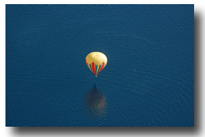The balloon drifts serenely across the lake