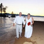 The newly married take a casual walk along the shore