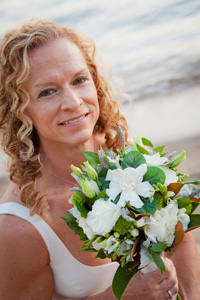 Bride smiles while holding up her bouquet