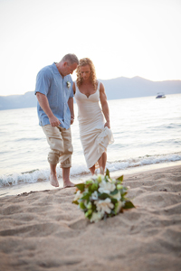 Couple dipping their toes in the sand by the waterside